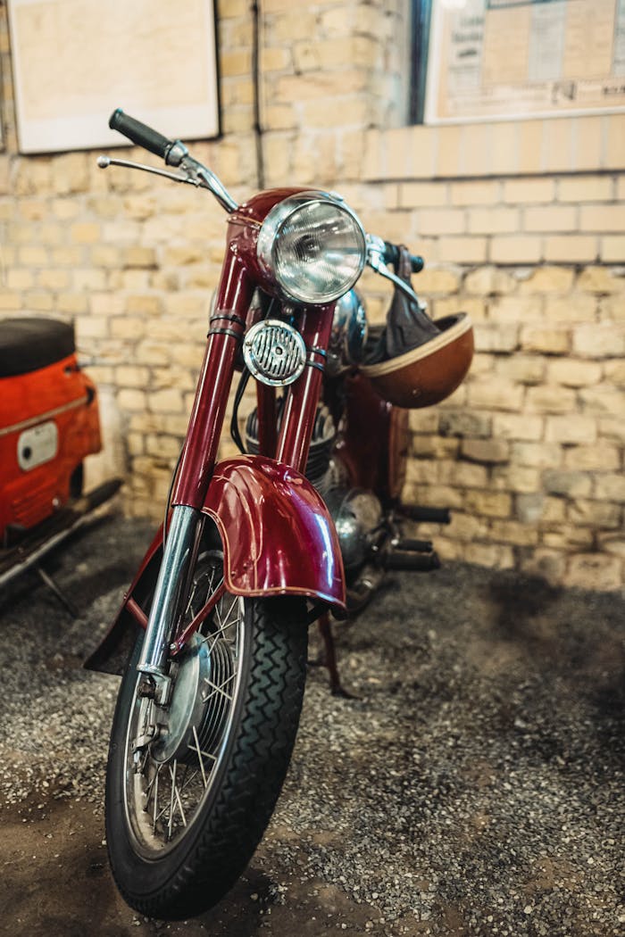 Classic Jawa 353 motorcycle displayed in an indoor rustic garage setting with a warm vintage feel.